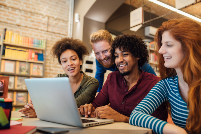 People smiling and looking at a laptop