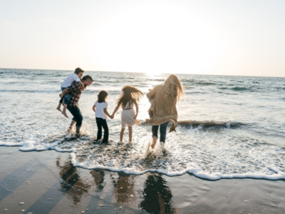 Family running into the waves at the beach