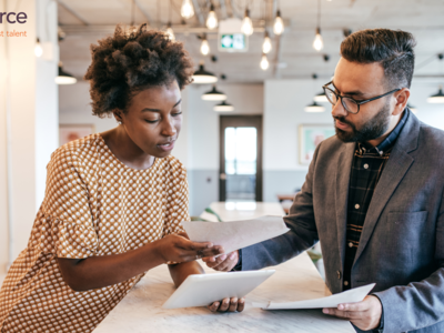 Female and male colleagues in an office setting discussing documents