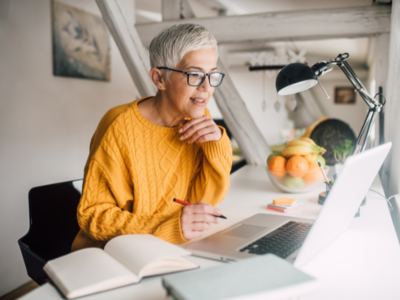 Person in a yellow jumper looking at laptop