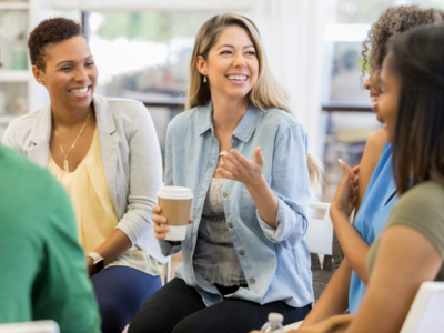 Photo of people talking and smiling over a coffee